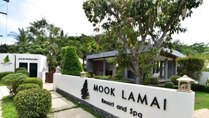 Señal de Mook Lamai Resort and Spa con exuberante jardín tropical de fondo.