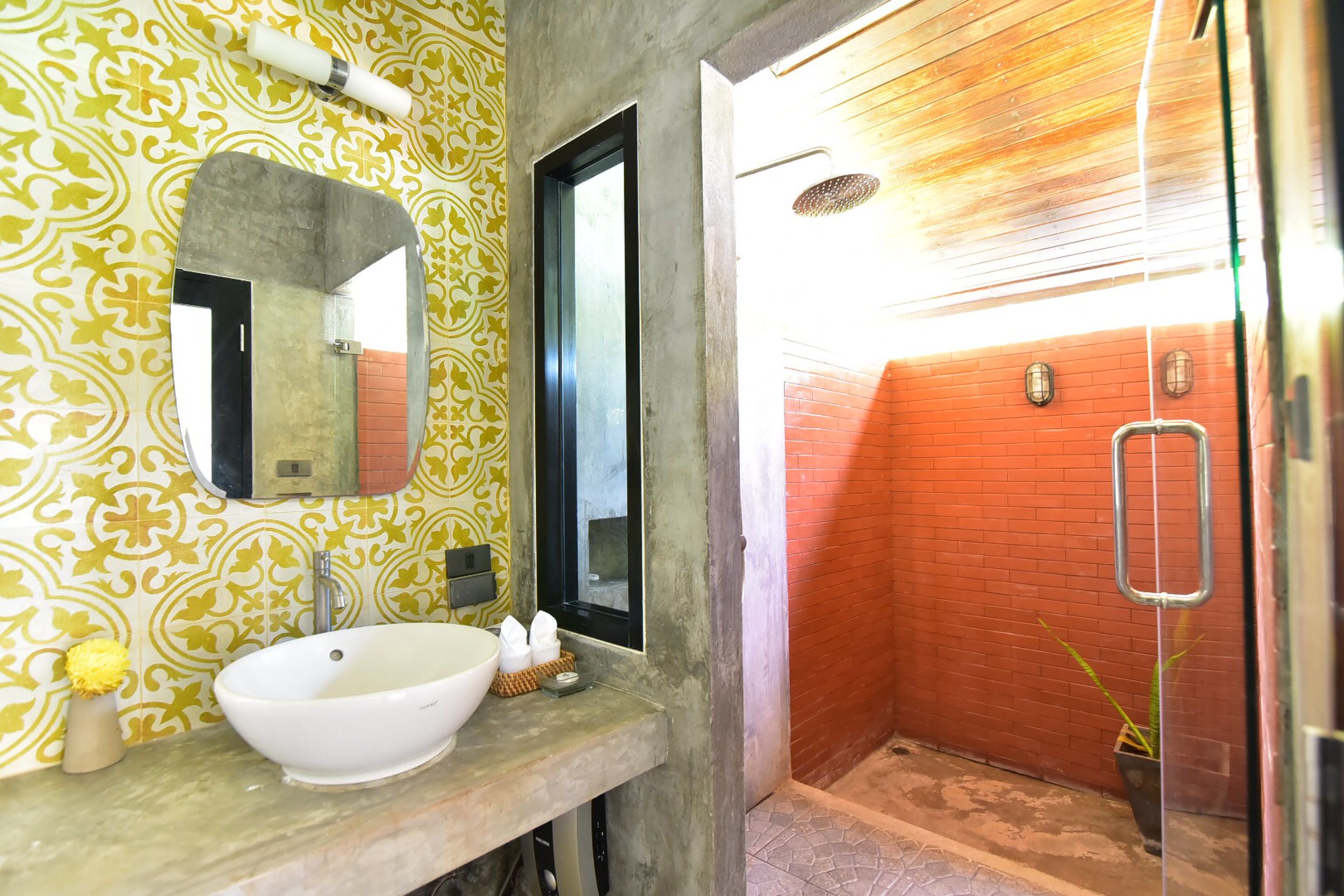 Un bagno con lavandino, specchio e doccia bianchi.
