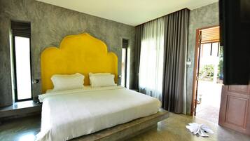 Un dormitorio con una cama grande, un cabecero amarillo singular y vistas al exterior.