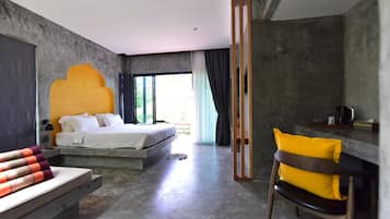 A modern bedroom with a large bed, a seating area with a chair, and a view of the outdoors.