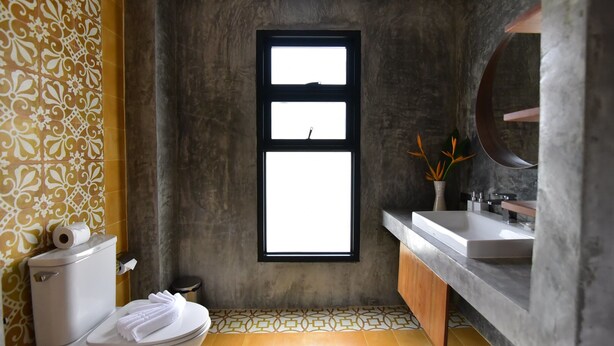 A bathroom with a toilet, sink, and window. - Mook Lamai Resort and Spa (Ko Mook)