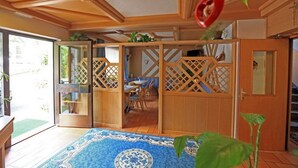A traditional Japanese-style room with sliding doors, a dining area, and a view of the outdoors.