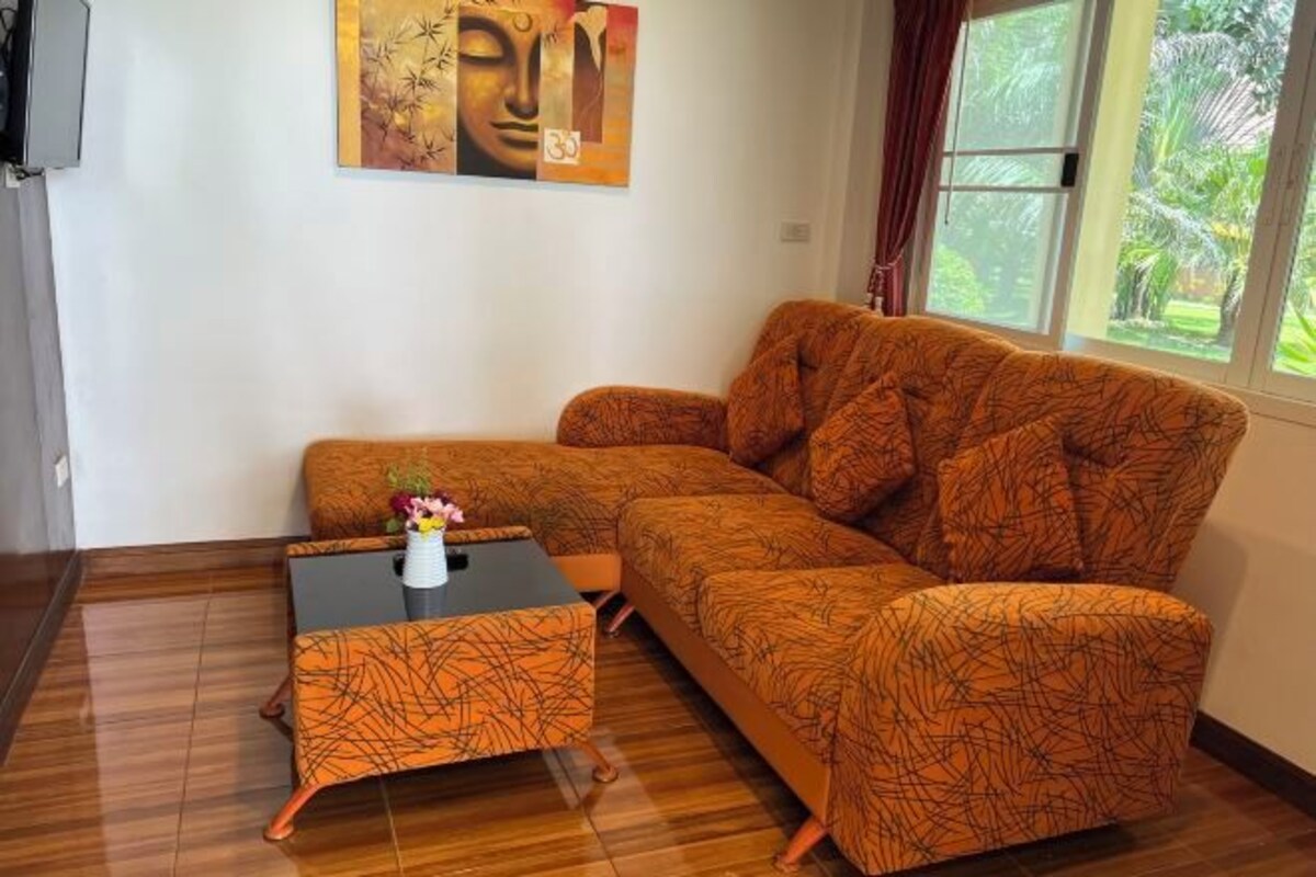 A living room with a patterned sofa, a small coffee table, and a painting on the wall.