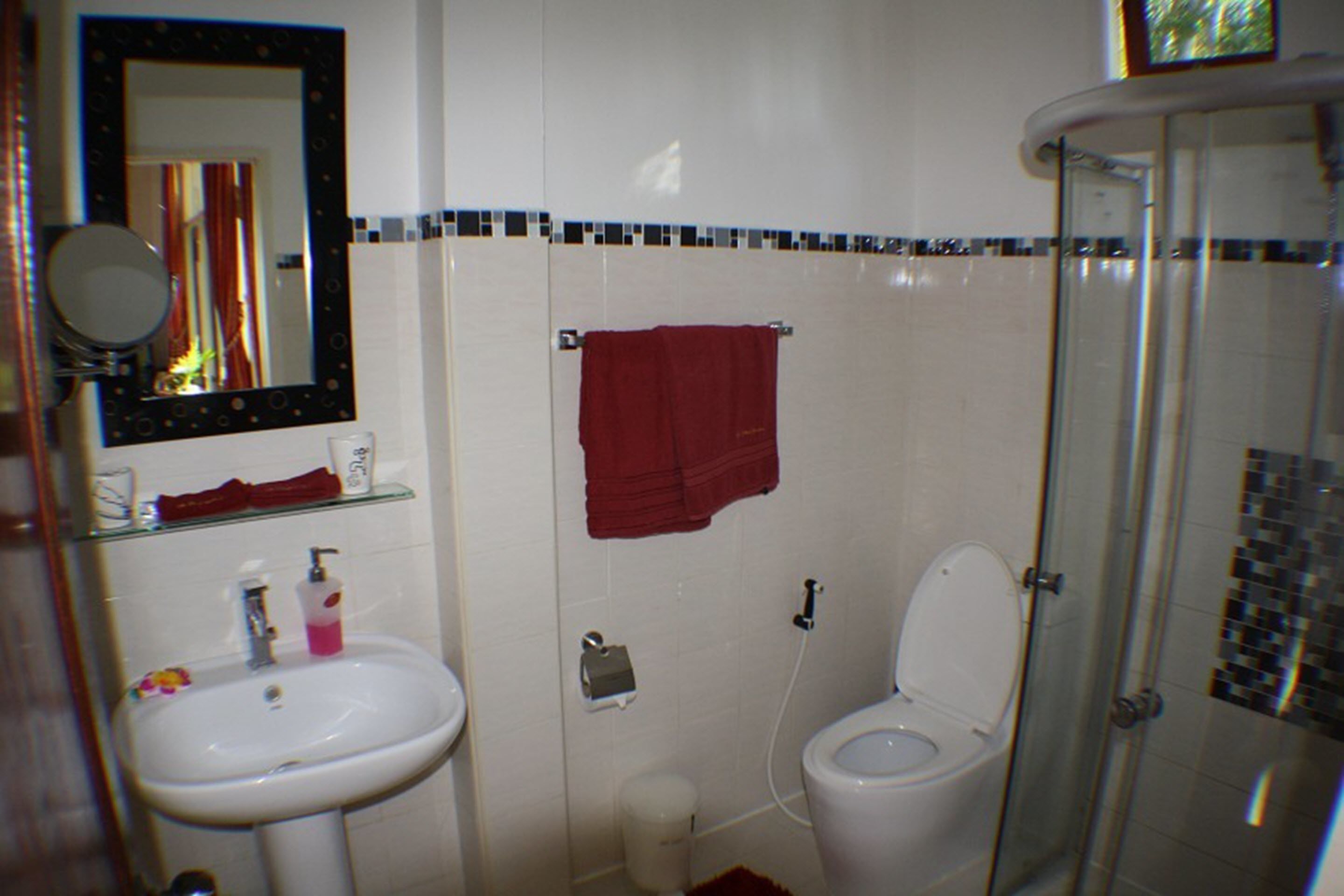 Un baño con lavamanos, inodoro y ducha.
