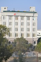 Un hôtel à plusieurs étages doté d’une façade moderne, avec un logo bien visible sur le toit.