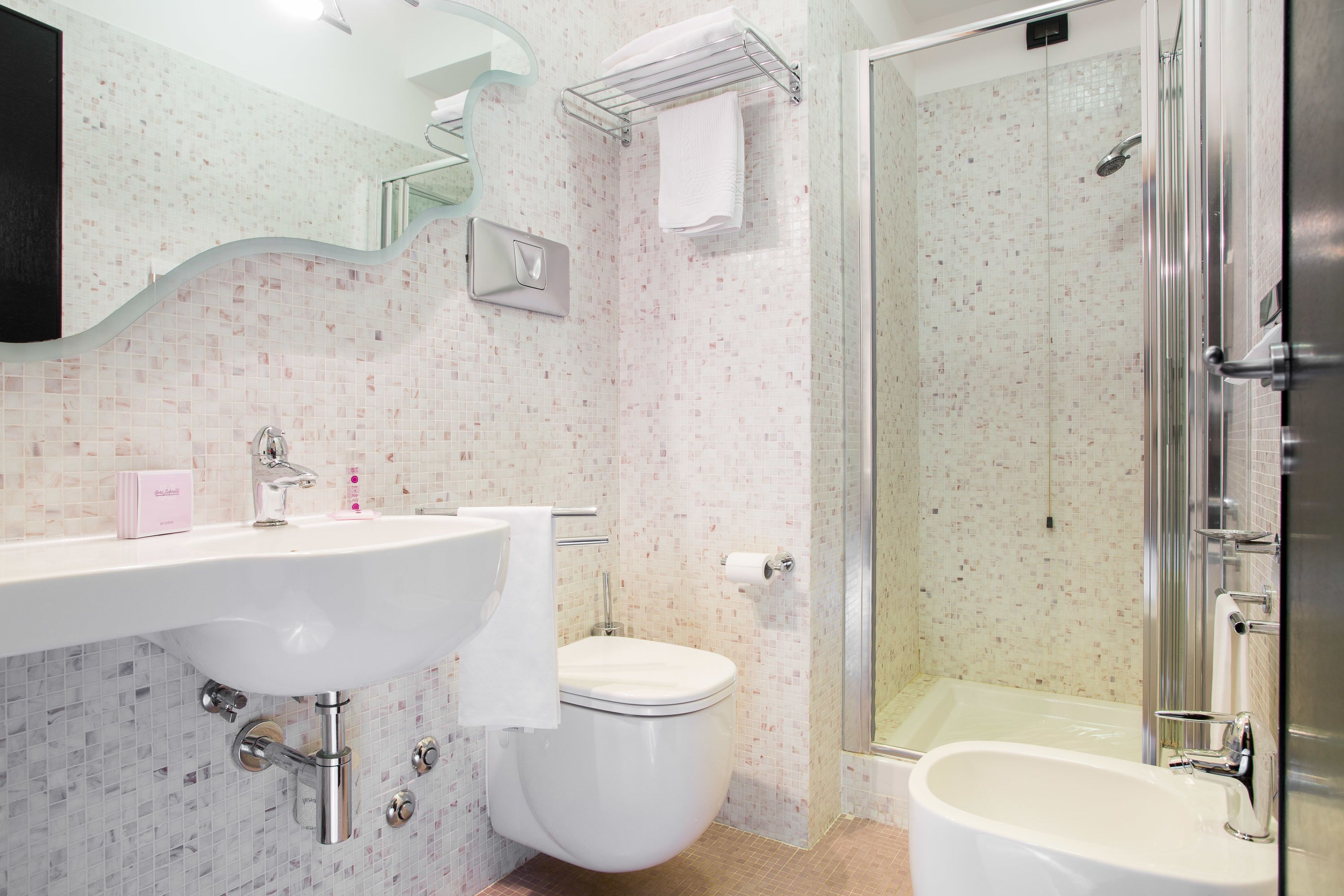 A bathroom with a sink, toilet, and shower.