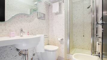 A bathroom with a sink, toilet, and shower.