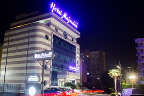 A hotel with a modern design, featuring a prominent neon sign and a checkered facade. - Hotel Majorana (Rende)