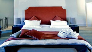 A modern bedroom with a large bed, two bedside tables, and a bench. - Podere Castel Merlo Resort (Villongo)
