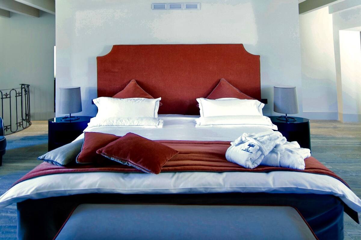 A modern bedroom with a large bed, two bedside tables, and a bench.