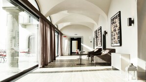 A spacious hallway with high ceilings and large windows, leading to a balcony area. - Podere Castel Merlo Resort (Villongo)