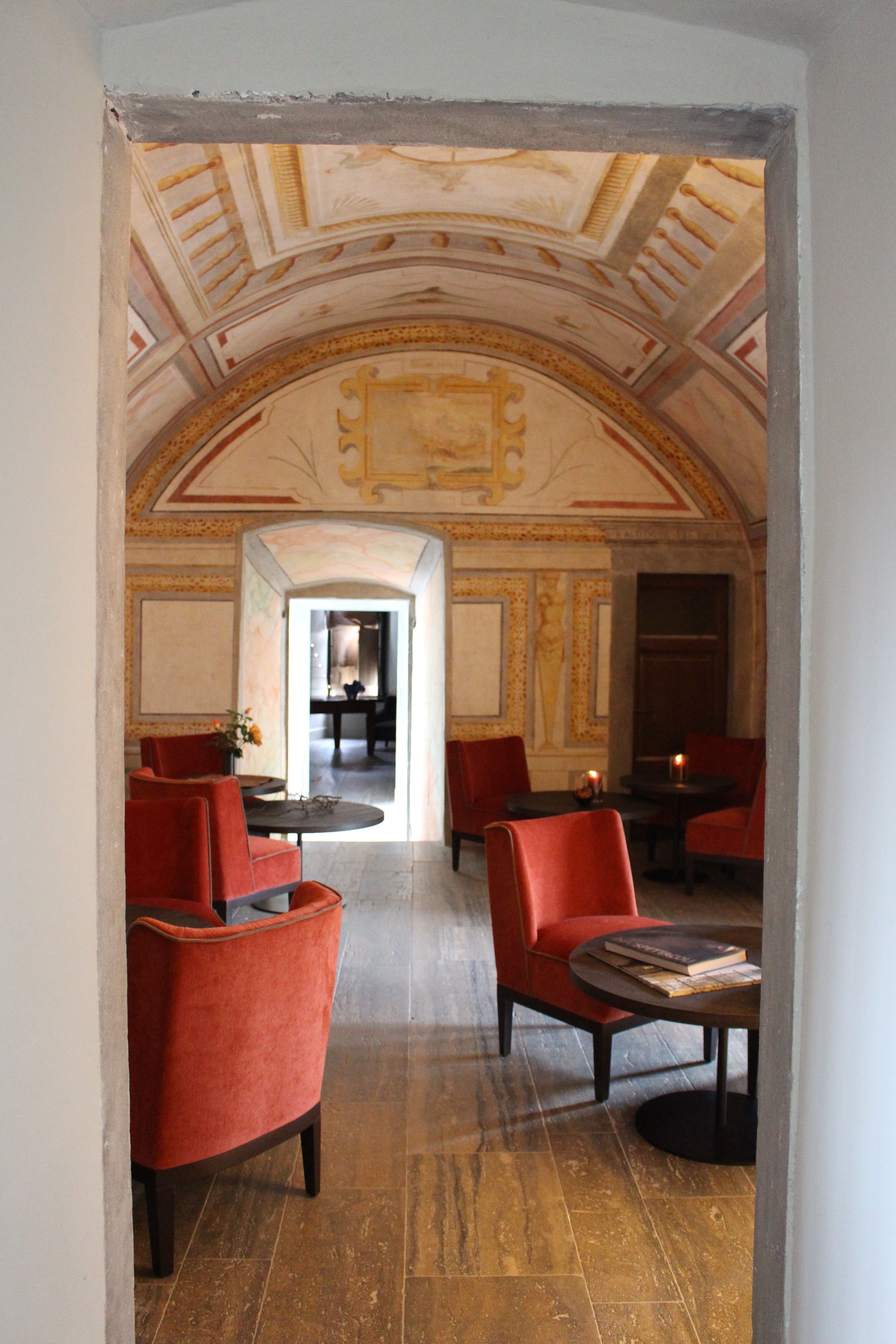 A room with red chairs, a table, and a ceiling with decorative elements.