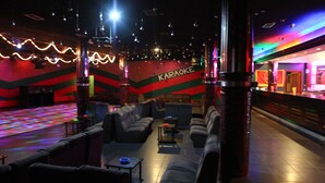 A karaoke room with seating and a stage area. - Hotel JR (Sanxenxo)