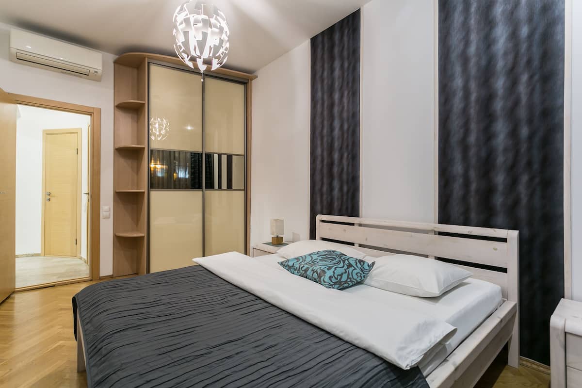 Une chambre moderne avec un lit, une armoire et un luminaire mural original.