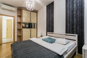 Un dormitorio moderno con cama, armario y una lámpara de pared original.