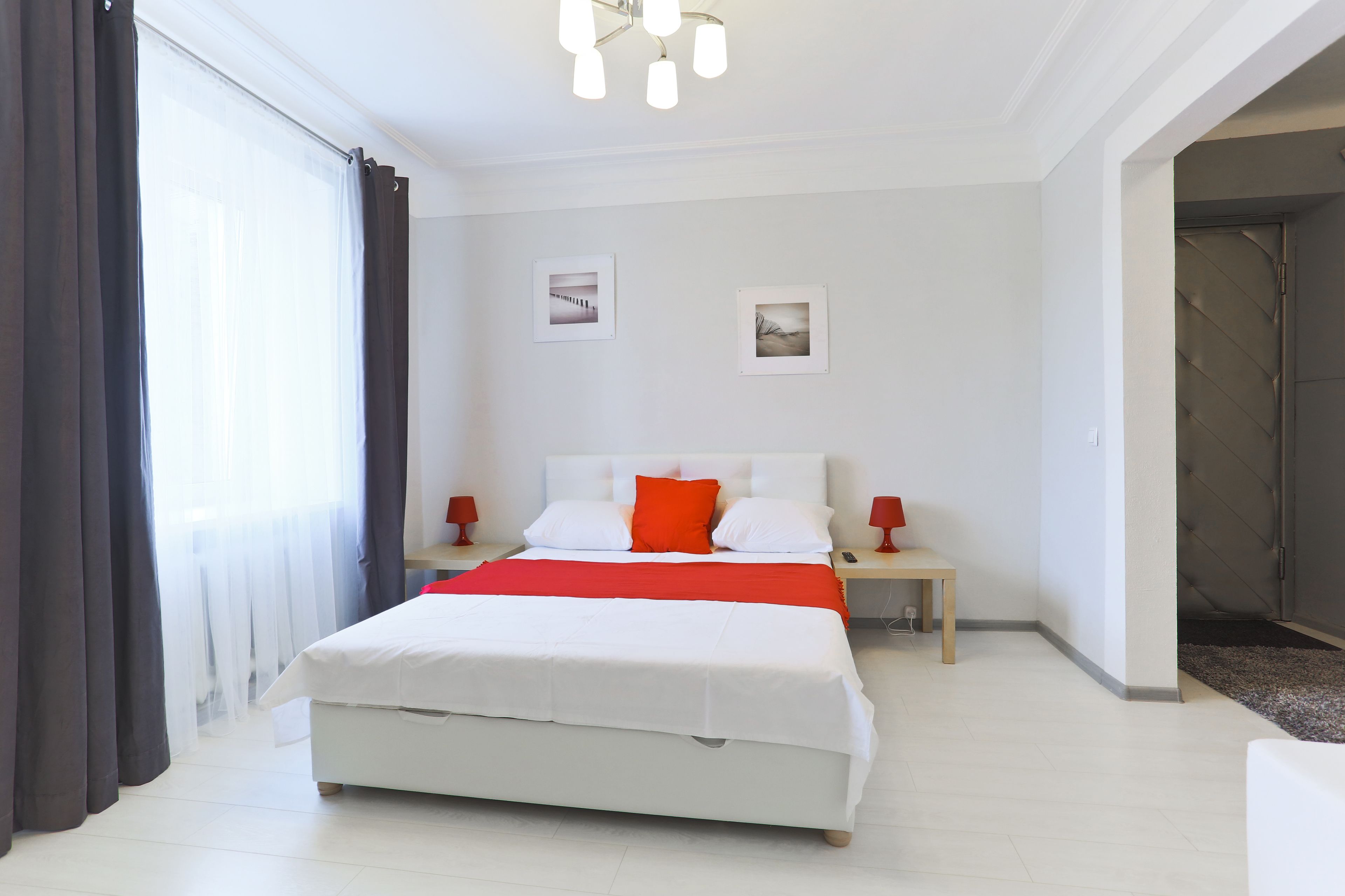 A modern bedroom with a large bed, two bedside tables, and a nightstand.