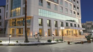 A multi-story hotel with a modern design, featuring a prominent sign at the top. - B Business Hotel & Spa (Antalya)
