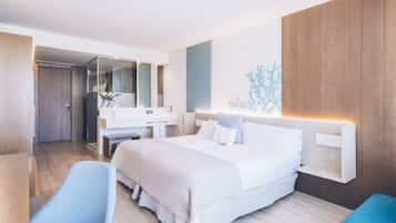 Una habitación de hotel moderna con una cama grande, un escritorio, una silla, un baño con espejo y un estante montado en la pared.