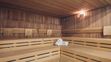 A sauna with wooden benches and a towel rack.
