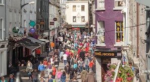 A crowded street with shops and buildings. - Galway Luxury Seaview Apartments (Galway)