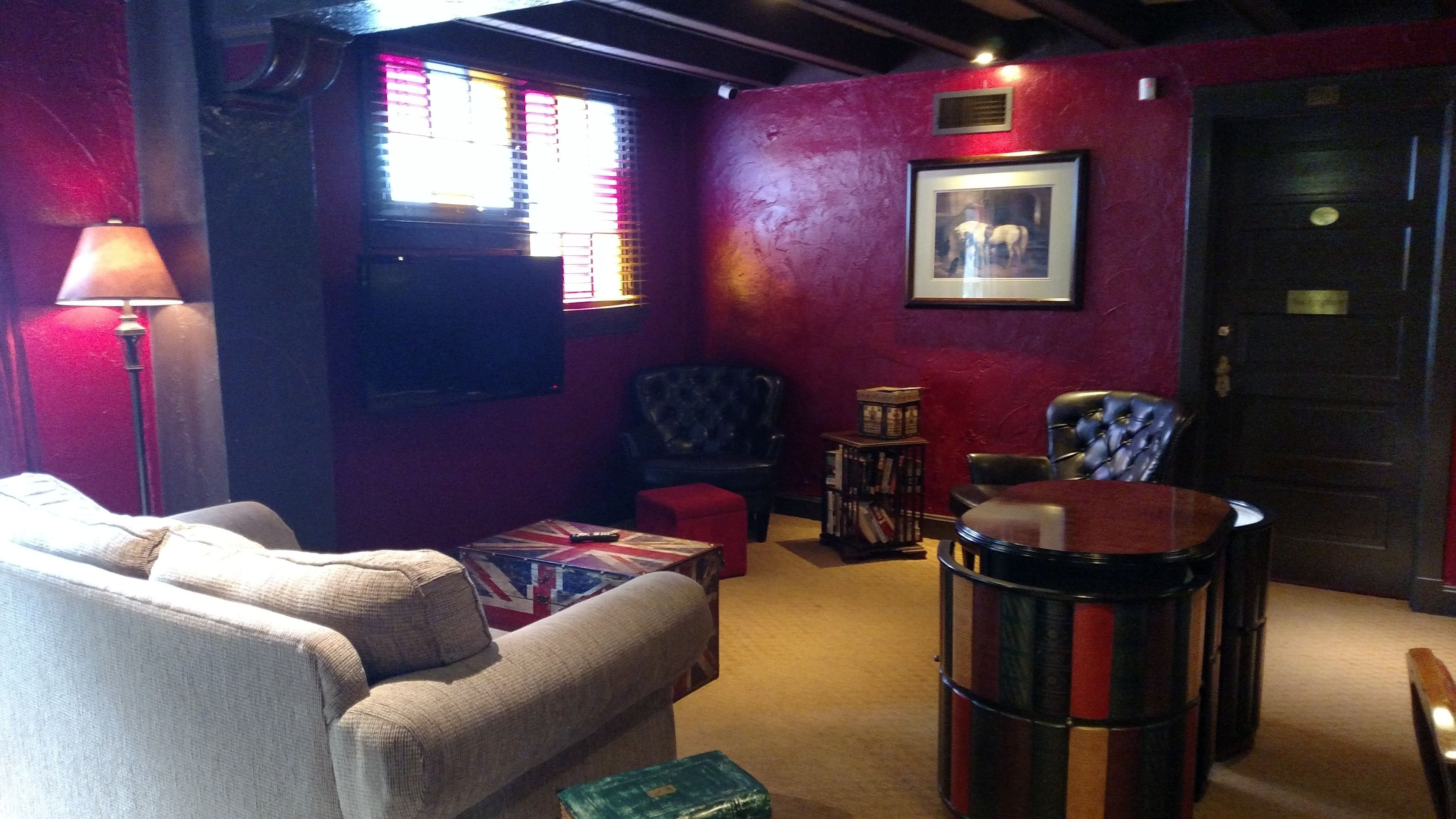 A cozy room with a sofa, a drum set, and a framed picture on the wall.