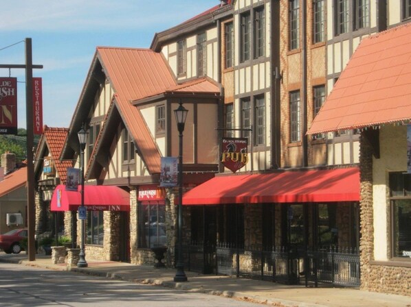 A traditional building with a pub sign, stone pillars, and a red awning. - Ye Old English Inn (Hollister)