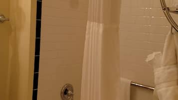 A bathroom with a bathtub, a shower curtain, and a towel rack.