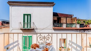 A balcony with a table set for breakfast, including croissants, pastries, and coffee. - Palazzo Sassi (Meta)