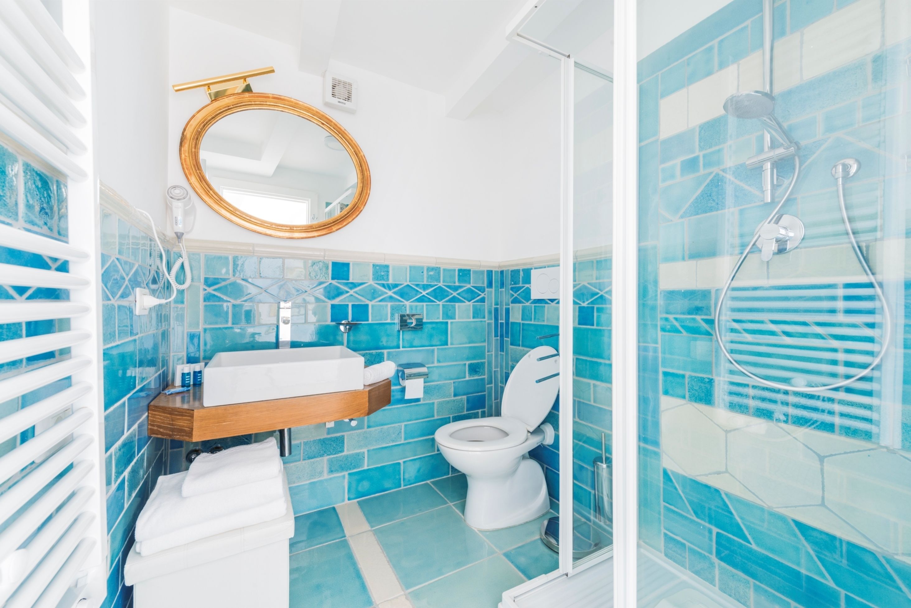 A bathroom with a white sink, a toilet, and a shower area.