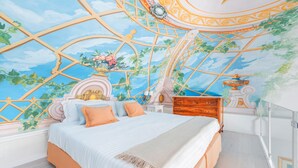 A bedroom with a large bed, a wooden dresser, and a decorative ceiling mural. - Palazzo Sassi (Meta)