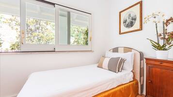 Un dormitorio con cama, ventana, cuadro enmarco y armario.