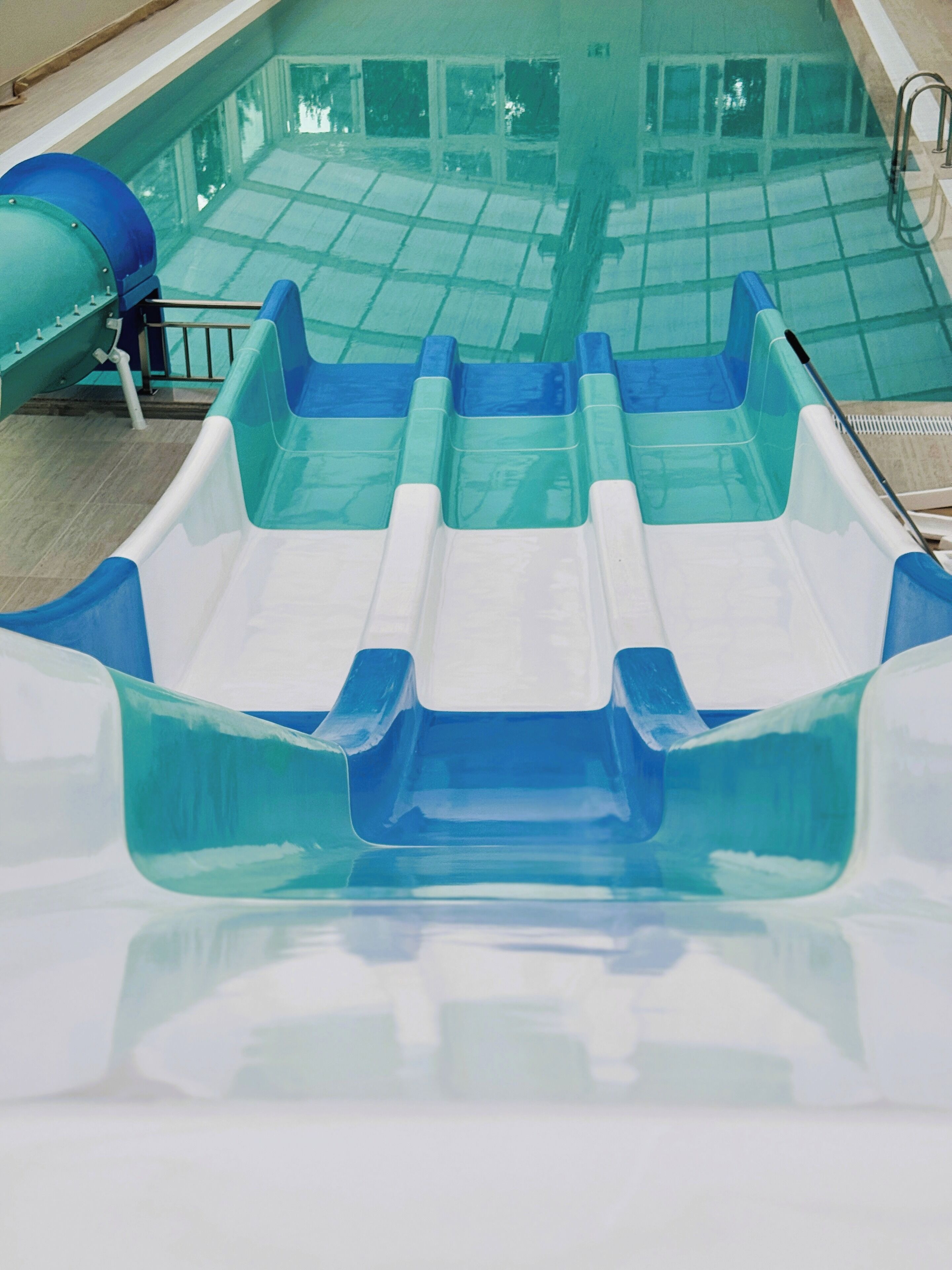 Une piscine avec un toboggan et un plongeoir.
