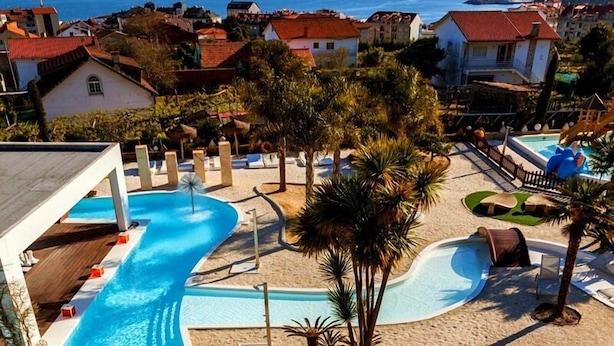 A resort with a swimming pool, sun loungers, and umbrellas.
