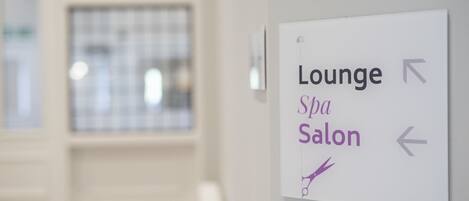 A sign indicating directions to the Lounge and Spa Salon.