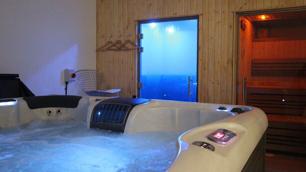 Un jacuzzi con vista al mar a través de una puerta.