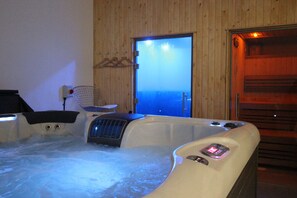 Un jacuzzi con vista al mar a través de una puerta.