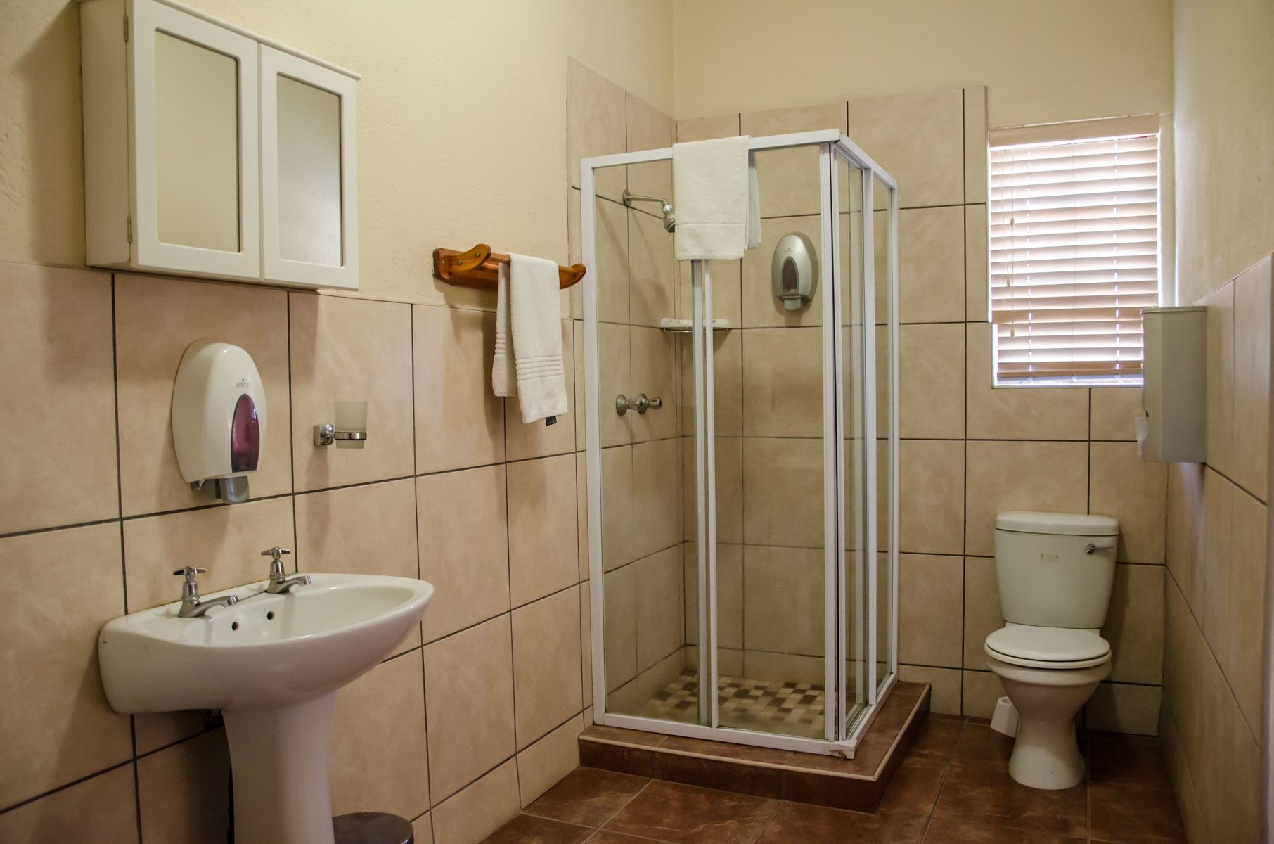 A bathroom with a sink, toilet, and glass-enclosed shower.
