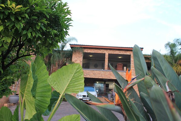 A two-story house with a brick exterior and a car parked in front.
