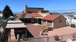 A residential property with a covered patio, a garage, and a small garden area. - Anchorage Guest House (Plettenberg Bay)