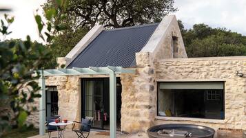 Une maison en pierre dotée d’une grande terrasse, d’un jacuzzi et d’une pergola.
