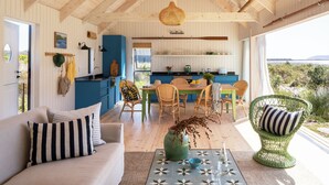 A spacious living area with a sofa, chairs, a coffee table, and a view of the outdoors. - Coot Club (Stanford)