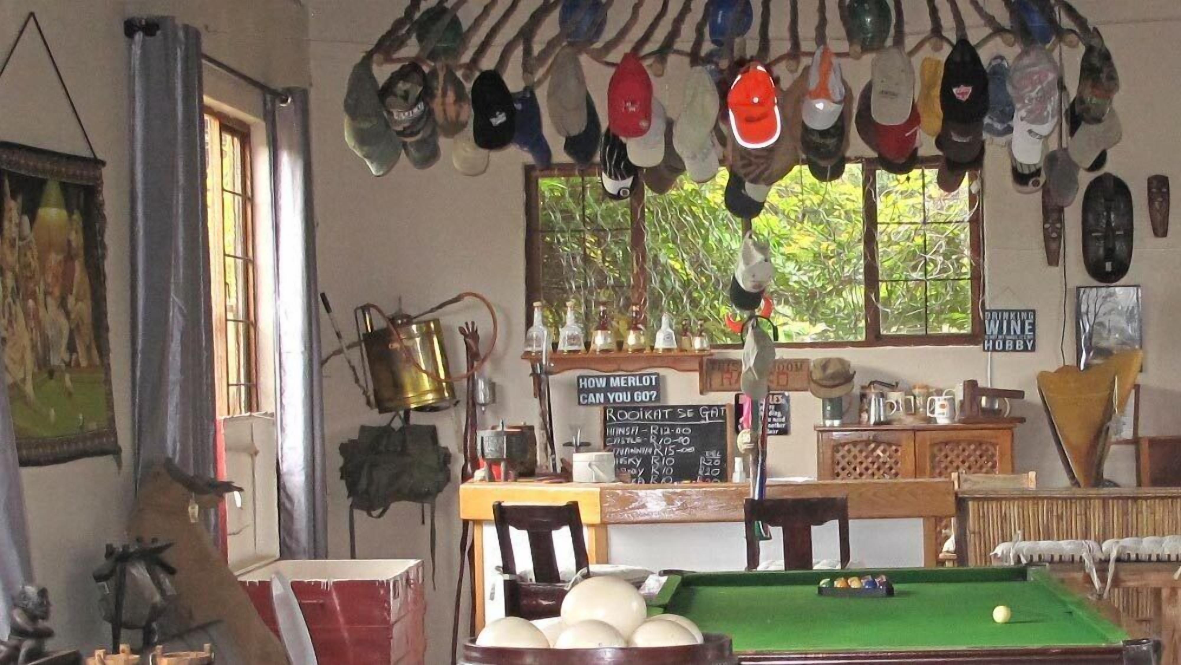 Una sala de billar con mesa de billar, sillas y un menú en pizarra.