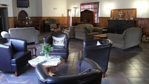Un salon spacieux avec des canapés en cuir, une cheminée et un téléviseur.