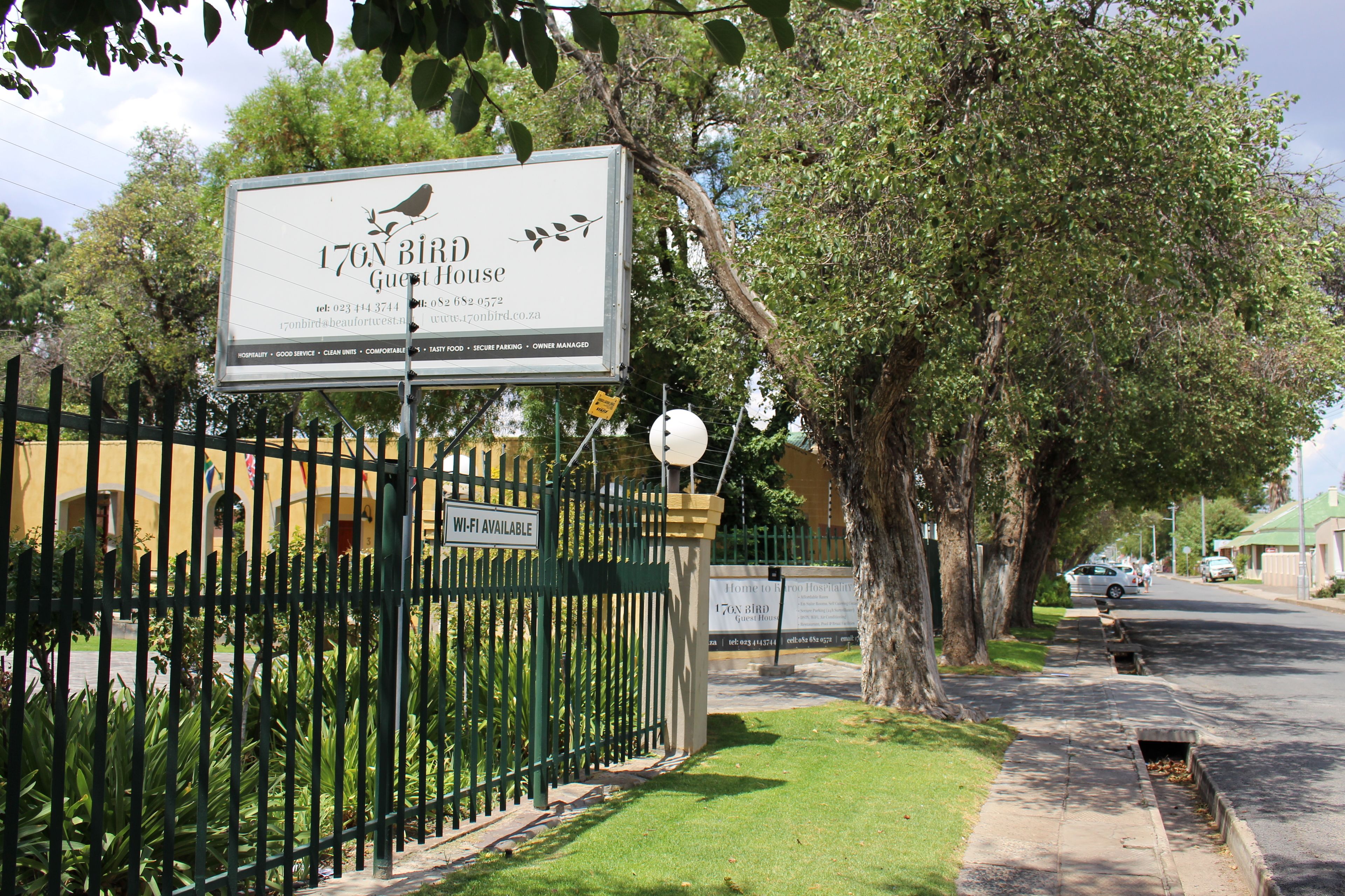 A sign for 176 Bird Guest House with contact information and amenities listed.