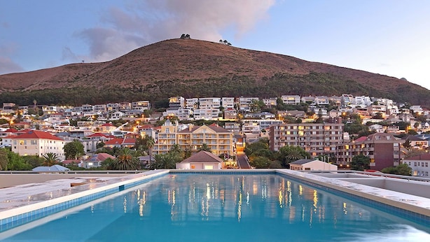 Una piscina con vistas a un pueblo en la ladera.