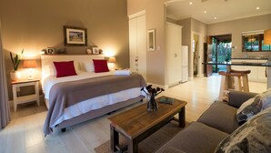 Une chambre à coucher comprenant un lit, des tables de chevet, une commode, un banc en bois et une lampe de chevet.