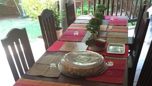 Una mesa de comedor dispuesta con individuales, una campana de cristal y una planta en maceta.