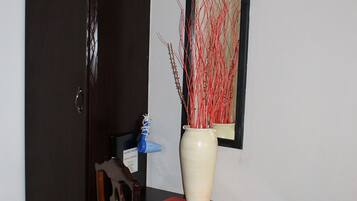 A room with a wooden cabinet, a desk with a vase, and a chair.