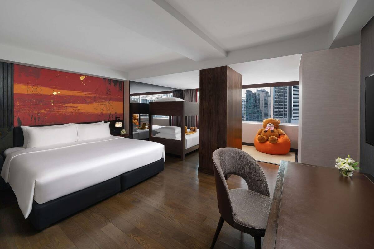 Una habitación de hotel moderna con una cama grande, un escritorio y vistas a la ciudad.