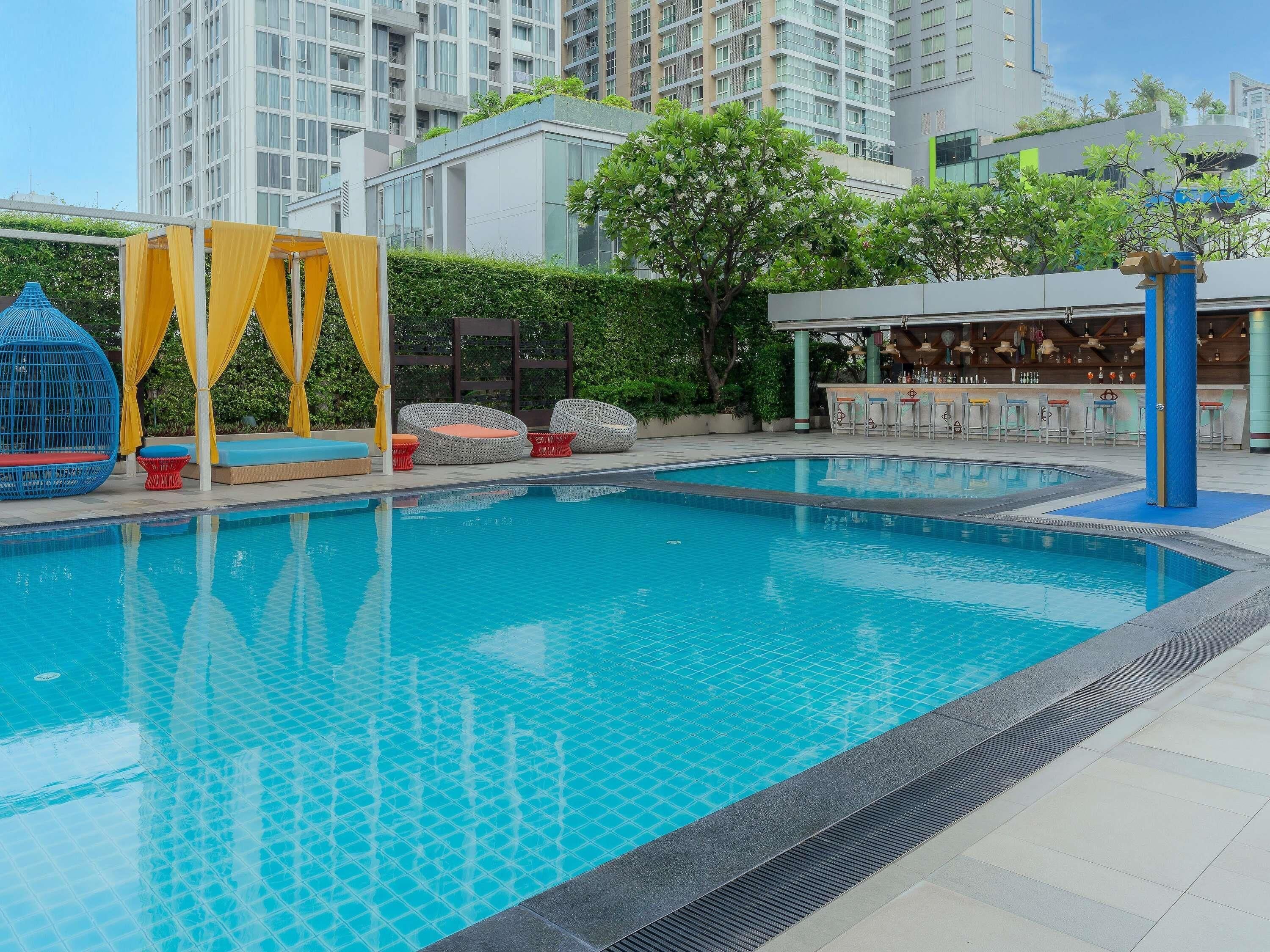 A swimming pool with lounge chairs and a bar area.
